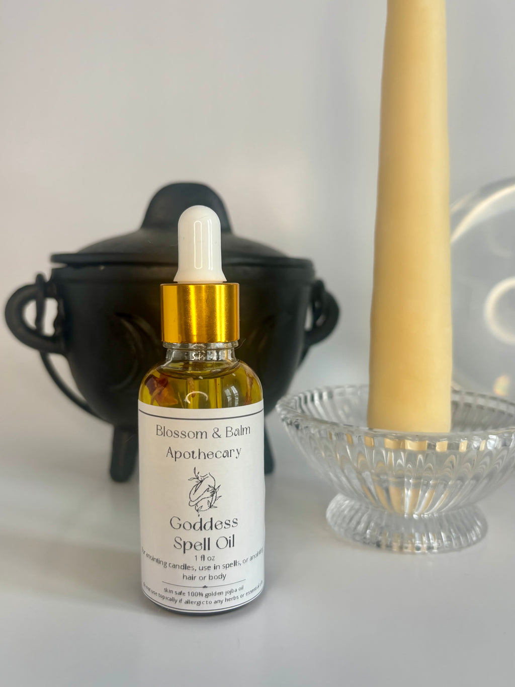 Bottle of Goddess Spell Oil from Blossom & Balm Apothecary with a dropper on a white surface.