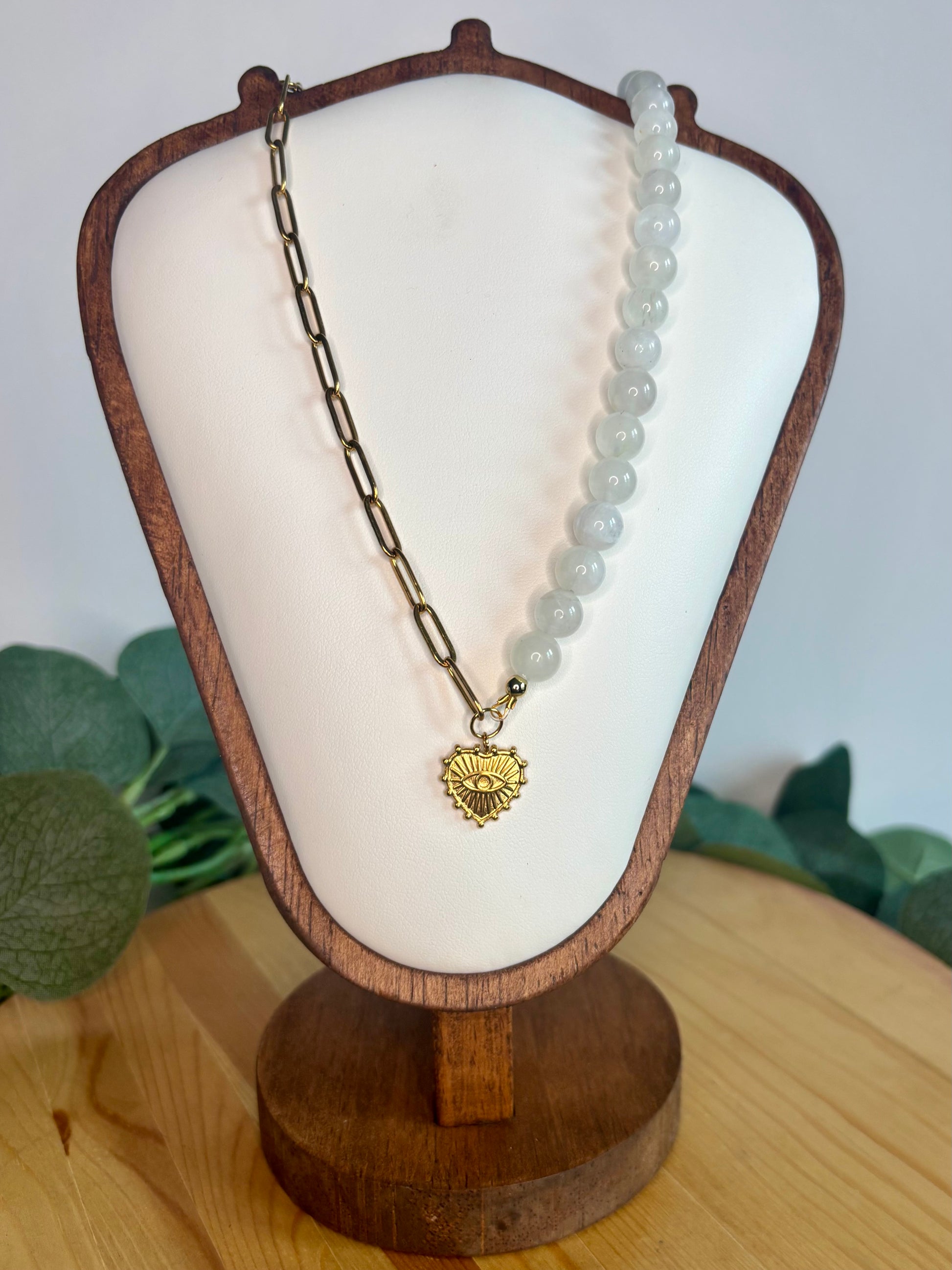 Necklace with half paperclip chain and half rainbow moonstone beads, with a heart shaped gold evil eye charm.